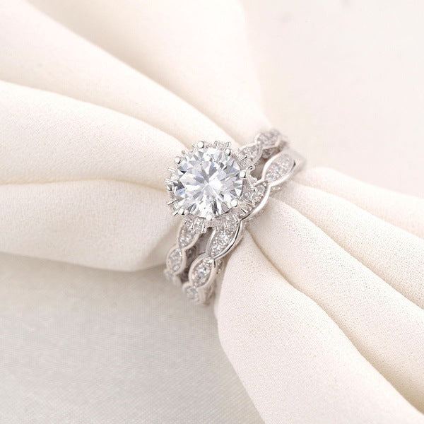 Elegant zircon alloy ring set displayed on white fabric, featuring a large central zircon and leaf-inspired band design.