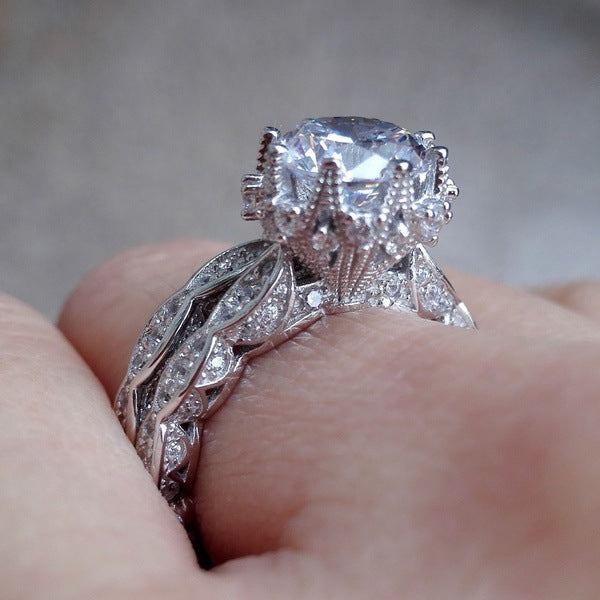 Close-up of electroplated zircon ring on finger, highlighting the brilliant-cut zircon and ornate alloy band.